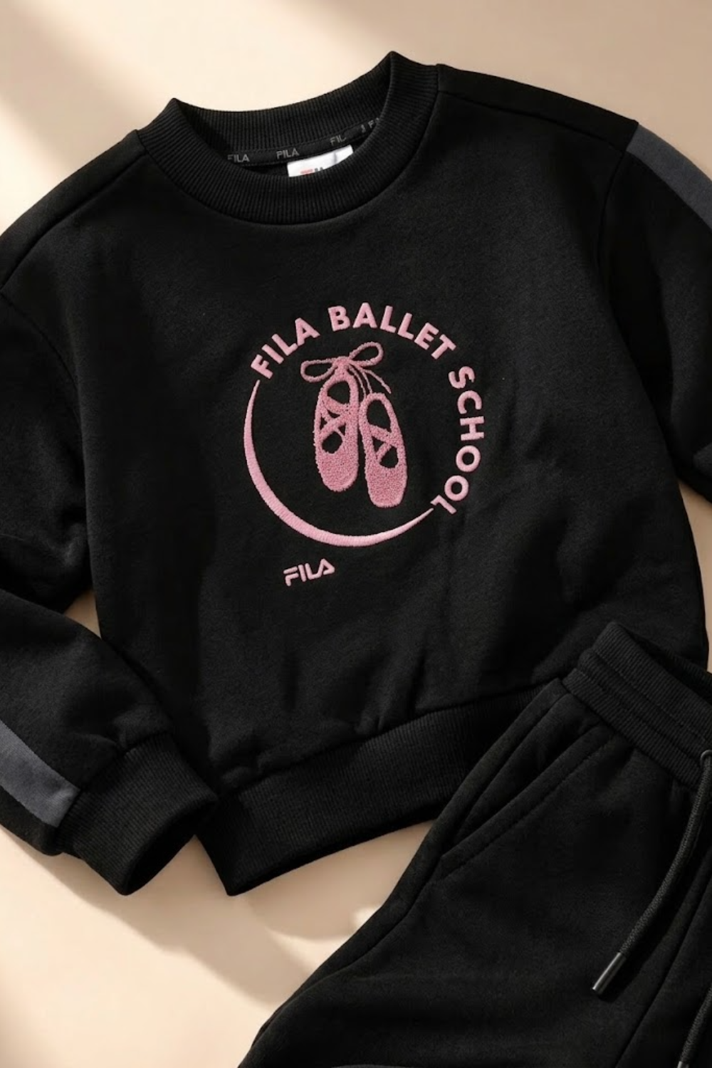 תקריב להדפס FILA BALLET SCHOOL בוורוד על סווטשירט שחור של סט פוטר FILA לבנות - דגם 122019418