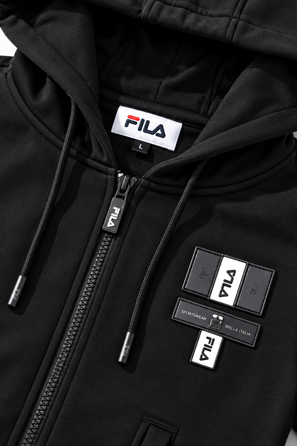 תקריב לוגו FILA ורוכסן על קפוצ׳ון פוטר שחור לבנים | פליפר